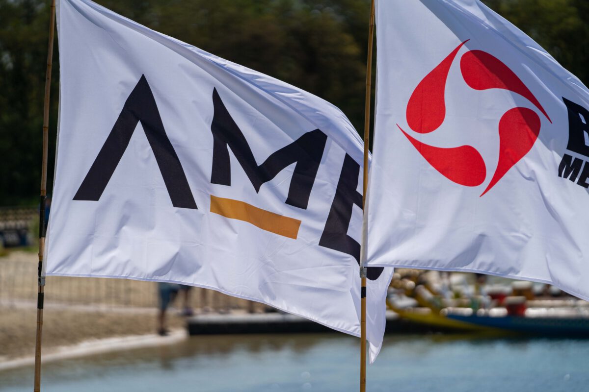 Foto van twee vlaggen met bedrijfsnamen die het Drakenbootfestival de Kempen sponsoren.